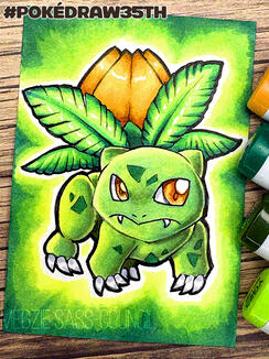 A photo of an ACEO marker drawing of a SHiny Ivysaur. The background is a green vignette. The photo is taken on top of scrapbooking paper with a wood texture. A few markers visible at the side of the photo. Drawn for the PokéDraw35th project. ©Megzie Sass-